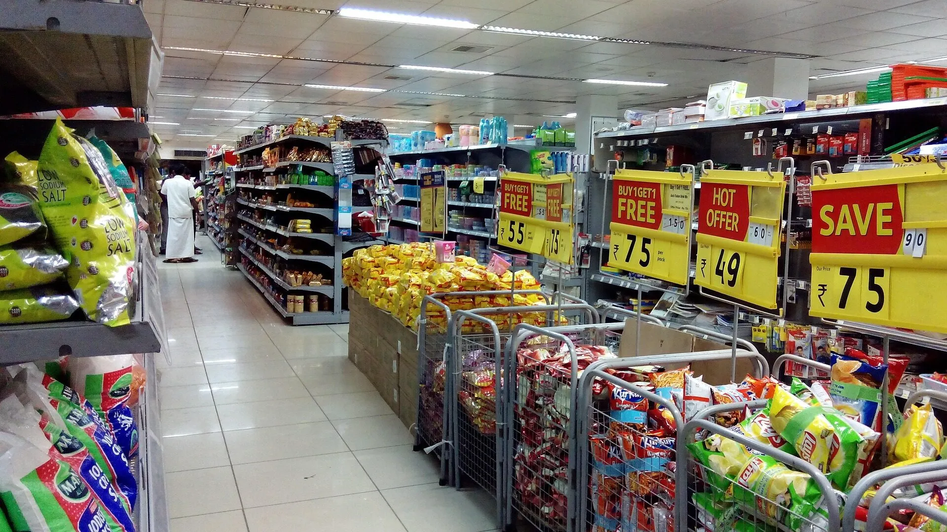 Allée d’un commerce de détail, étalages de collations et affiches de promotions