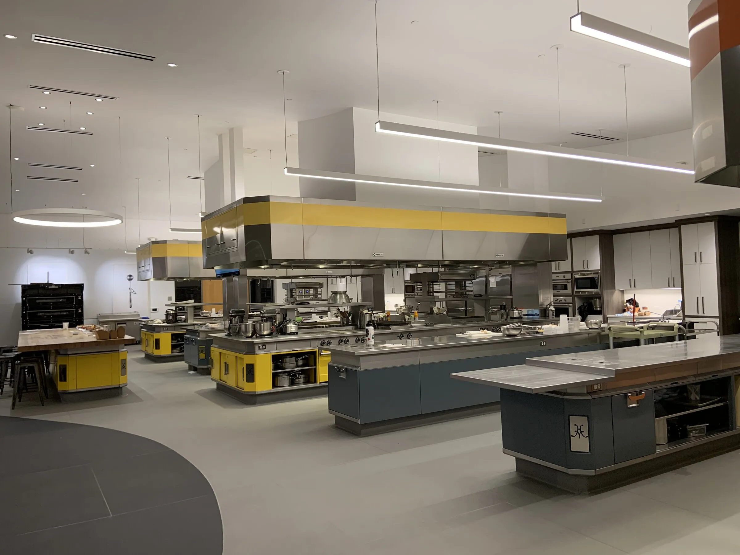Cuisine commerciale en inox : îlots de préparation, hottes et fours alignés