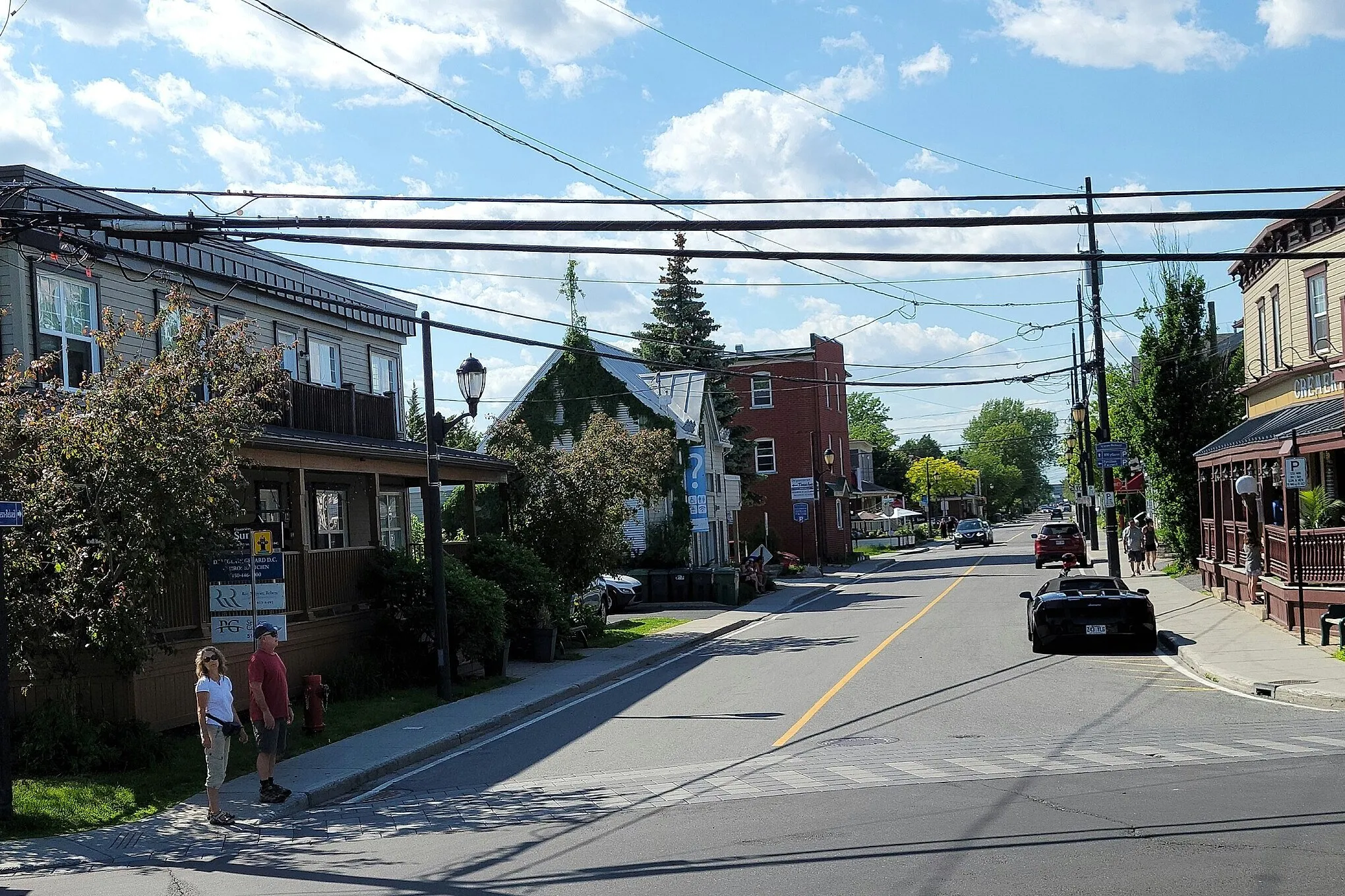 Rue Richelieu dans le Vieux-Beloeil : maisons de bois à galeries et bâtiment de brique