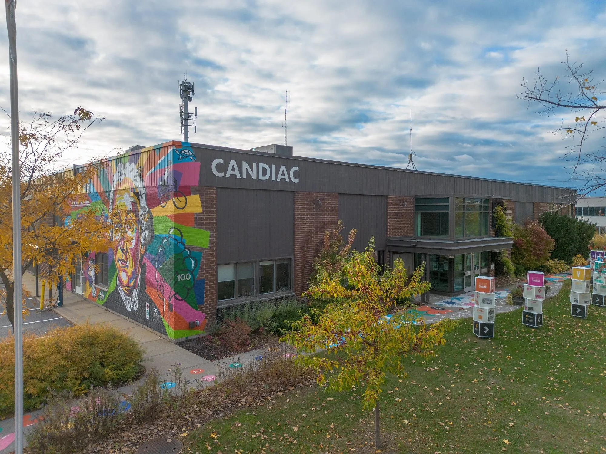 Bâtiment arborant le nom de Candiac et une murale colorée