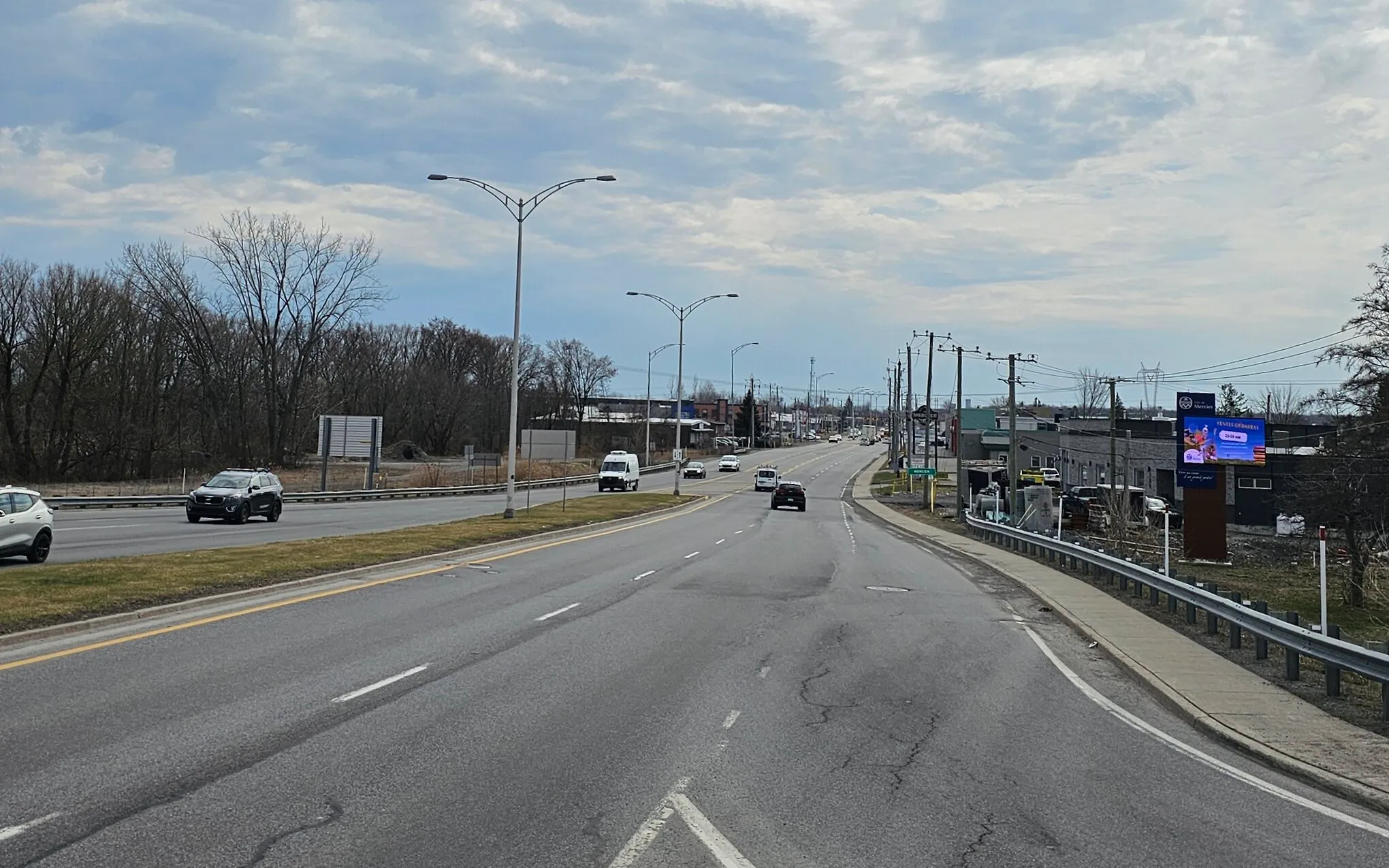 Entrée ouest de Mercier par le boulevard Saint-Jean-Baptiste, commerces et boisé en bordure